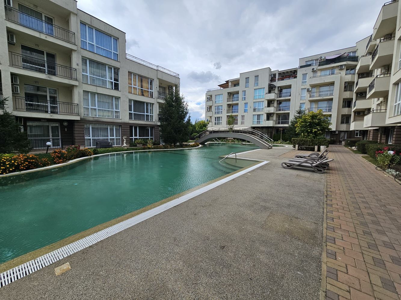 One-bedroom apartment surrounded by greenery in a complex with a swimming pool and children's playground